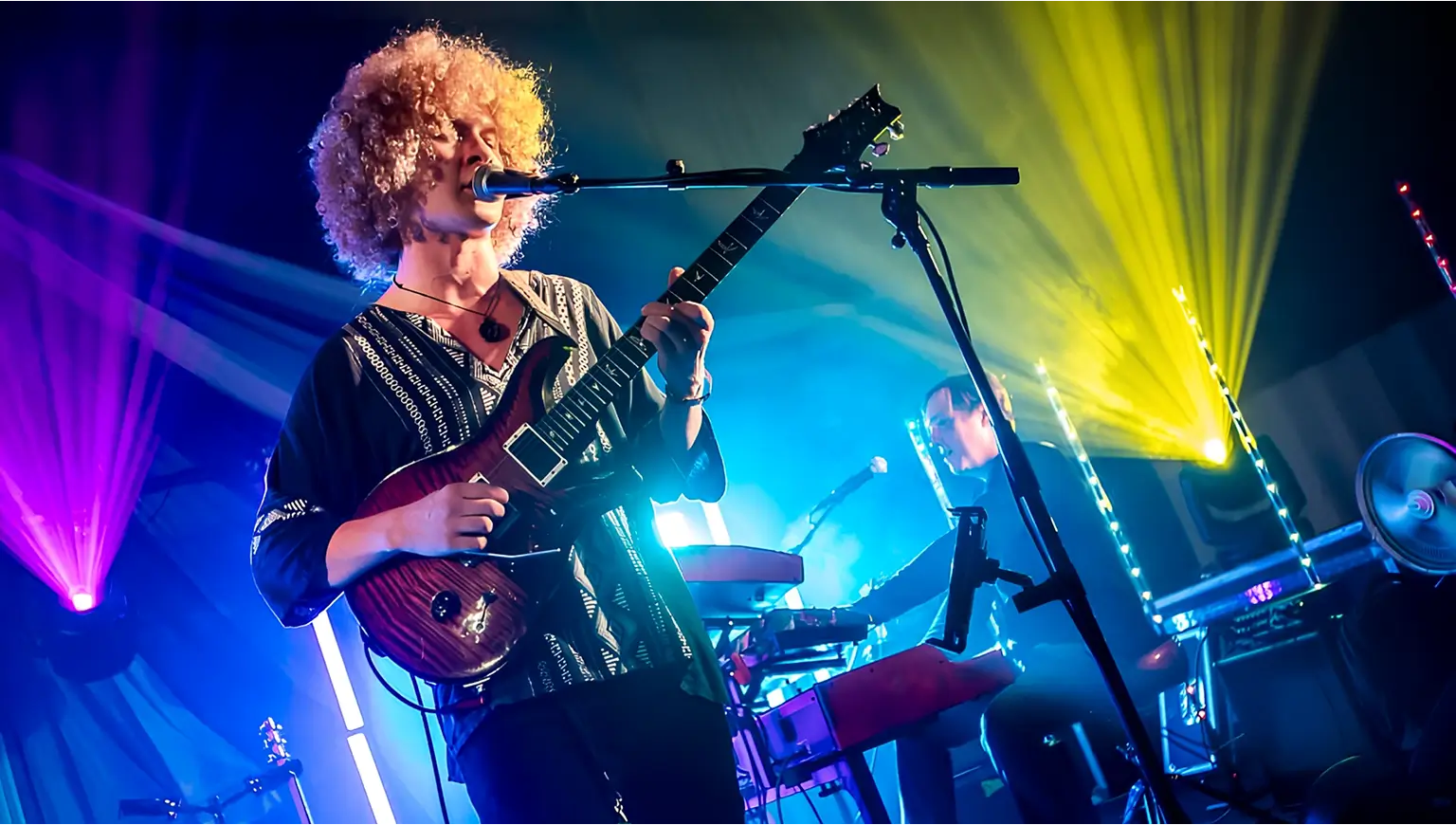 Isaac Hadden playing guitar and singing on stage