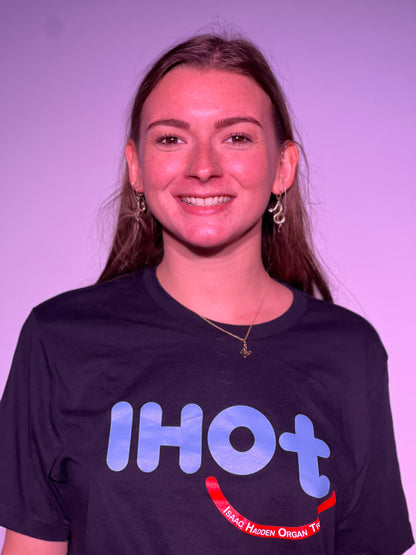 A young woman with brown hair and hazel eyes, smiling and wearing the Isaac Hadden Organ Trio black T-shirt.