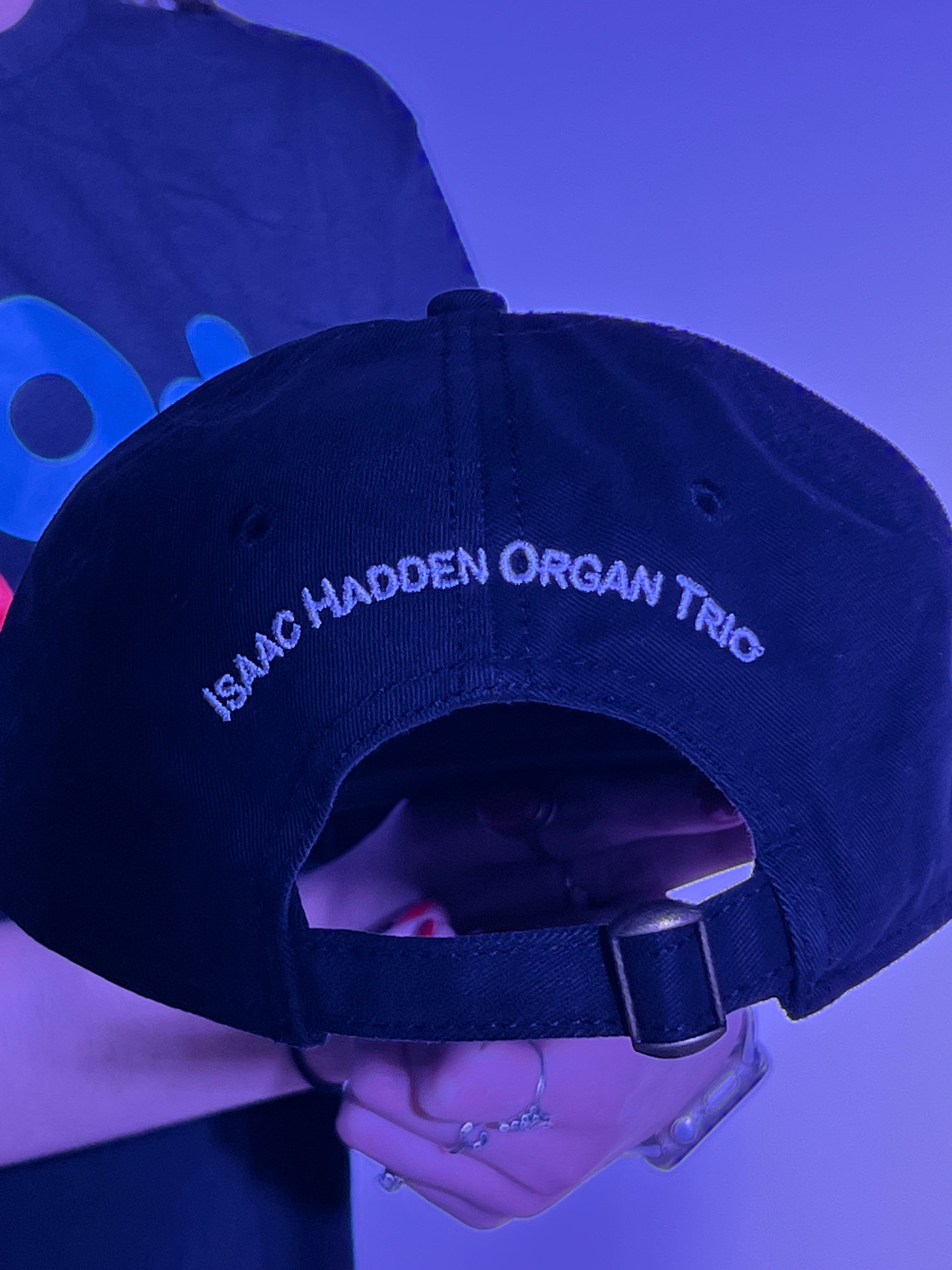 A portrait of back side of the Isaac Hadden Organ Trio logo on a black baseball cap.